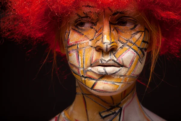 Ragazza in una parrucca rossa e brillante arte viso — Foto Stock