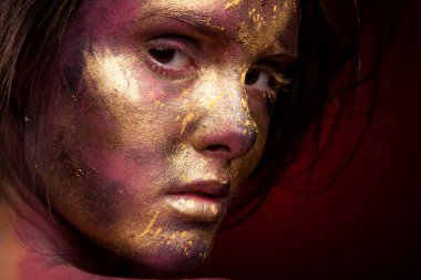 Yüzündeki altın boya ile kız