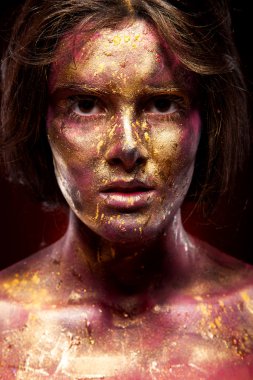 Yüzündeki altın boya ile kız