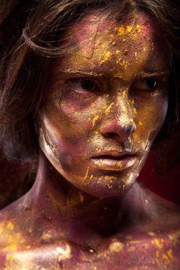 Yüzündeki altın boya ile kız