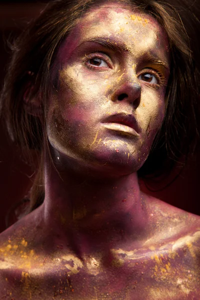 Menina com tinta dourada no rosto — Fotografia de Stock