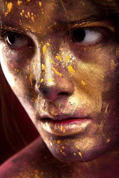 Girl with gold paint on face — Stock Photo, Image