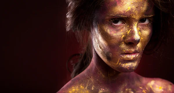 Girl with gold paint on face — Stock Photo, Image