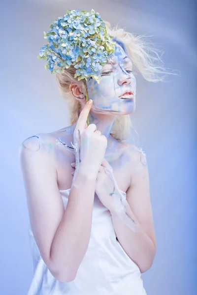 Mulher com arte facial e flores — Fotografia de Stock