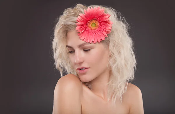 Blond tjej med gerbera blomma — Stockfoto