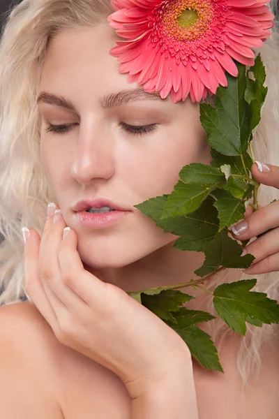 Blond meisje met gerbera bloem — Stockfoto