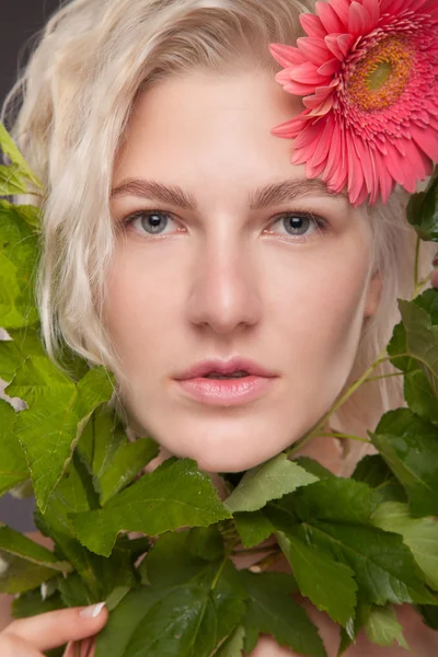 Blond meisje met gerbera bloem — Stockfoto