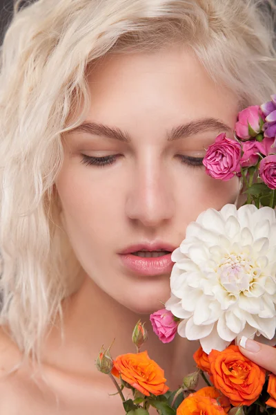 Blond meisje met bloemen — Stockfoto