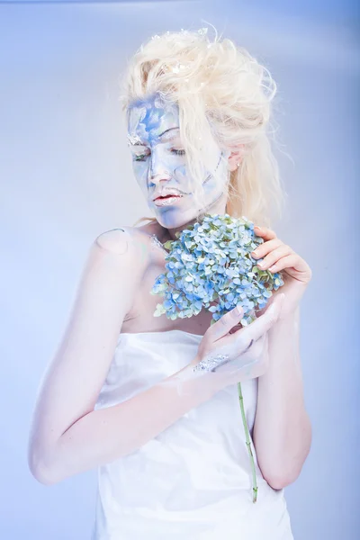 Mulher com arte facial e flores — Fotografia de Stock