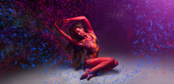 Woman relaxing and dancing with magic colored snow