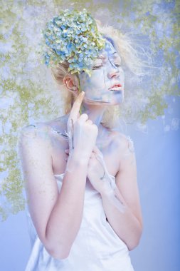 kadın bir çiçek tutan mavi yüz sanatı ile