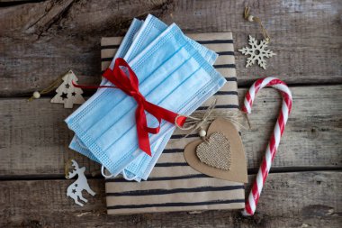 Noel ve yeni yıl için tebrik kartı şablonu. Üst Manzara. Hediye, şeker ve tıbbi maske.