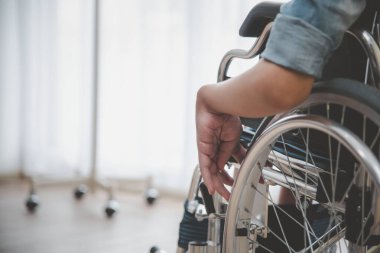 Tekerlekli sandalyedeki fiziksel engelli hastalar fiziksel anormallikleri ve tedavi yönergelerini kontrol etmek için hastaneye yatırılmayı bekliyorlar..