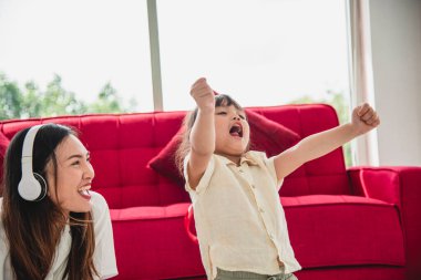 Küçük kız öğrenim geliştirme pratiği yapıyor, evde annesiyle bilgisayar üzerinden oyunlar oynuyor. Covid-19 virüsünden uzakta.