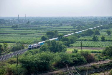 Pune Hindistan yakınlarındaki Uruli 'de elektrik lokomotifi tarafından çekilen yolcu treni..