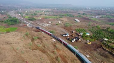 Pune India yakınlarındaki Shindawane 'de dizel bir lokomotif tarafından taşınan bir yolcu treninin hava görüntüleri..