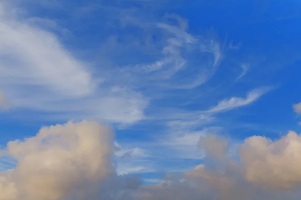 Verspreide pluizige wolken in de blauwe hemel — Stockfoto