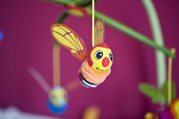 Pequena abelha pendurada acima da cama do bebê — Fotografia de Stock