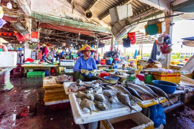 HOI AN, VİETNAM 2024, 15 Ağustos: Yerel Vietnamlı satıcılar Hoi An 'ın kapalı pazarındaki işlek bir tezgahta taze balık ve deniz ürünleri satıyorlar