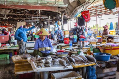 HOI AN, VİETNAM 2024, 15 Ağustos: Yerel Vietnamlı satıcılar Hoi An 'ın kapalı pazarındaki işlek bir tezgahta taze balık ve deniz ürünleri satıyorlar