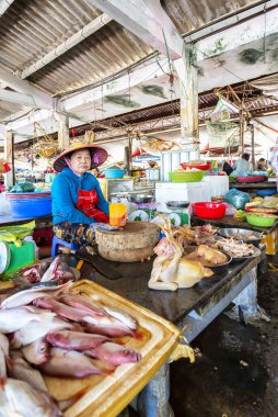 HOI AN, VİETNAM 2024, 15 Ağustos: Yerel Vietnamlı satıcılar Hoi An 'ın kapalı pazarındaki işlek bir tezgahta taze balık ve deniz ürünleri satıyorlar