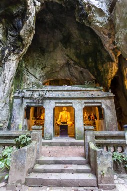 Marble Dağları 'ndaki bir kireçtaşı mağarasında parlayan bir Budist heykeli ve sunağı olan Grotto Tapınağı, Da Nang, Vietnam
