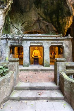 Marble Dağları 'ndaki bir kireçtaşı mağarasında parlayan bir Budist heykeli ve sunağı olan Grotto Tapınağı, Da Nang, Vietnam