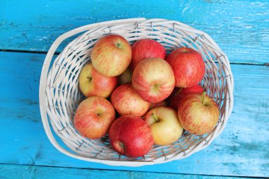 Olgun elma beyaz hasır sepet.