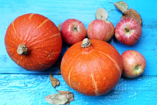 Maçãs vermelhas com abóboras de laranja na velha mesa de madeira Imagem De Stock