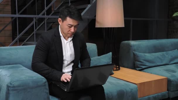 Asiatischer Geschäftsmann arbeitet an einem Laptop. Ethnische Geschäftsmann sprechen Blick auf Laptop-Computer, Online-Konferenz Distanz Büro Chat Videokonferenz-Konzept. Webinar. Online-Seminar. — Stockvideo