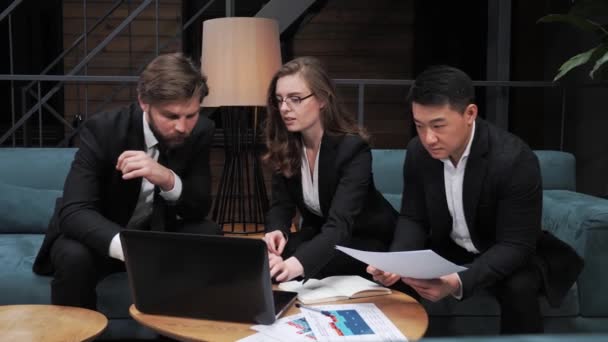 Three multiethnic businessmen consider a business contract offer in the field of IT technologies and the provision of legal consulting services using a laptop in a conference room business app. — Stock Video