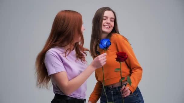 Dos jóvenes amigas de 20 años bailando con rosa de flores divirtiéndose. — Vídeos de Stock