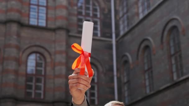 Mannelijke hand opgeheven houder diploma van de academie oproeping ceremonie. — Stockvideo