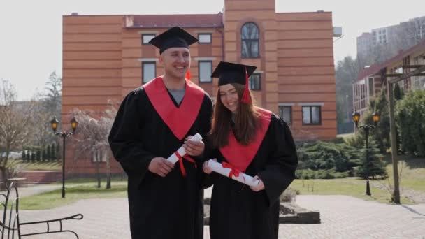 Migliori amici vanno alla cerimonia di laurea ridendo concetto di educazione. — Video Stock