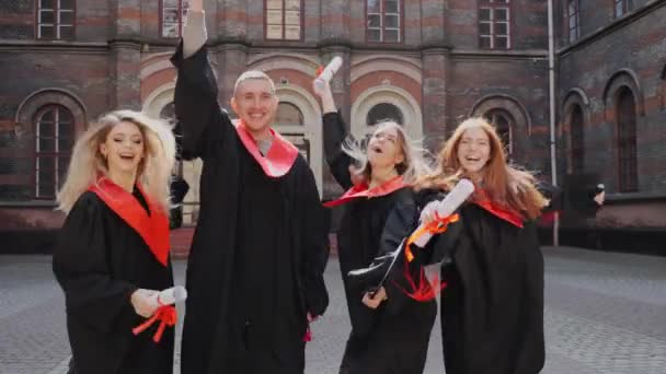 Les diplômés de l'Académie en manteaux se réjouissent de célébrer le jour de la graduation. — Video
