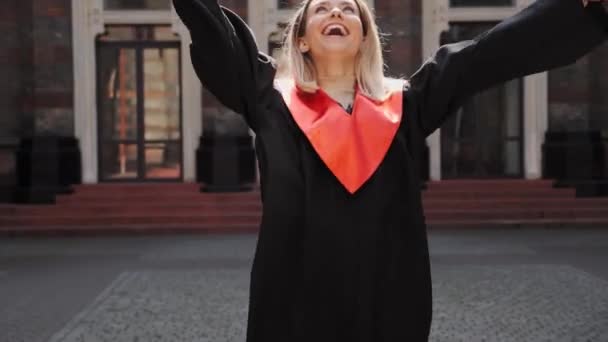 幸せな大学院生ブロンド女の子笑うダンス喜び上の卒業. — ストック動画