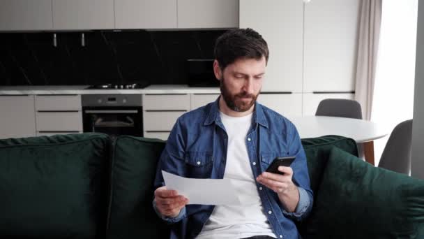 Hombre serio usando calculadora pagando factura en línea sentado en el escritorio de la oficina en casa. — Vídeo de stock