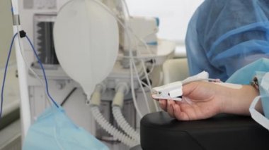 Bir kadın elinin yakınına bir algılama cihazı iliştirilmiş. Eylem. 