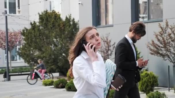 Biznesmenki w pośpiechu chodzą po schodach i rozmawiają przez telefon biegnąc do pracy. — Wideo stockowe