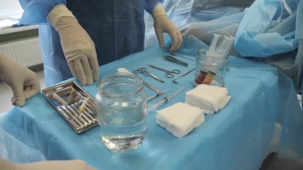 Βοηθός χέρια προετοιμάζει χειρουργικά εργαλεία πριν από τη χειρουργική επέμβαση. — Αρχείο Βίντεο