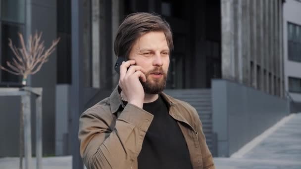Όμορφος άντρας έχει τηλεφώνημα και μιλάει σε εξωτερικούς χώρους. Τεχνολογική επικοινωνία. — Αρχείο Βίντεο