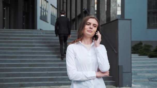Επιχειρηματίας έχει μια τηλεφωνική συνομιλία κατά τη συζήτηση σοβαρές ερωτήσεις εργασίας. — Αρχείο Βίντεο