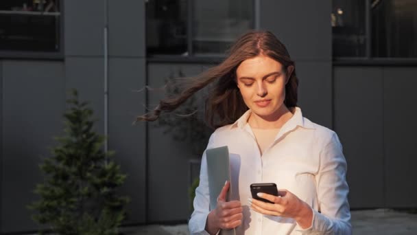 Empresária atraente digitando uma mensagem em seu Smartphone ao pôr do sol. — Vídeo de Stock