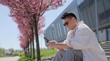 Asyalı Adam Sörf Yapıyor İnternet Sohbeti Mesajlaşması için Akıllı Telefon Uygulaması Kullanıyor.