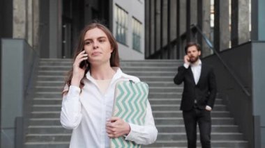 İş kadını dizüstü bilgisayarlı erkek arkadaşını arka planda tutuyor..