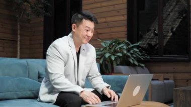 Chinese businessman waving having video call using web cam laptop remote work.