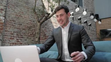 Handsome caucasian man rejoicing winner while looking on the screen of laptop.