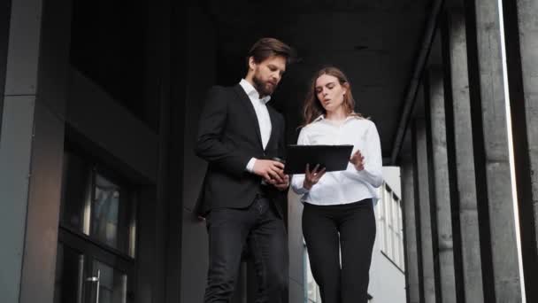 Businessman and businesswoman walking down the stairs in the morning with coffee — Vídeos de Stock