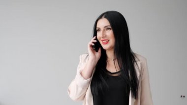 Real estate agent talking on the phone with buyers on isolated gray background.