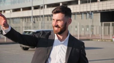 Gülümseyen sakallı iş adamı el sallayan arkadaşın içinden geçiyor..